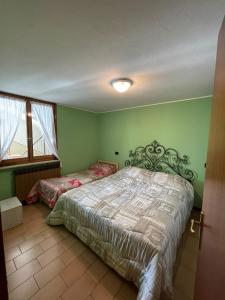una camera verde con un letto e una finestra di Rosa Mountain Lake Iseo Hospitality a Bossico