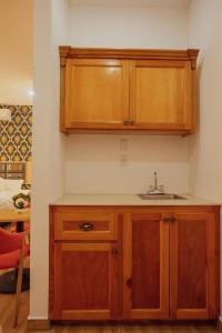 uma cozinha com um lavatório e armários de madeira em July AirBnB em Lower Princeʼs Quarter
