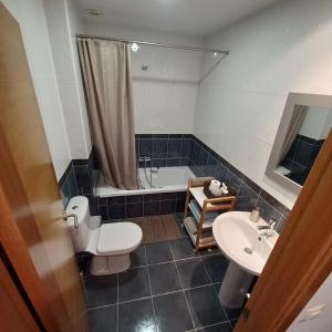 a bathroom with a toilet and a sink and a tub at Apartamento Mar de Sal in Finisterre +13 photos