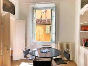 a table and chairs in a room with a window at Homelivia, VIEUX NICE, appartement de charme, clim balcon in Nice