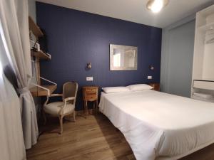una camera d'albergo con due letti e una sedia di Los Patios de Santander a Santander