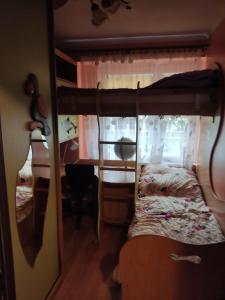 ajar view of a bedroom with a bunk bed and a desk at Przy Parku in Jarosław