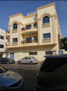 un edificio con coches estacionados frente a él en Guest House, en Dubái