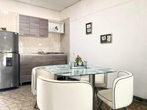 a kitchen with a table and chairs and a refrigerator at Apto #6 hermoso y amplio in Ríohacha