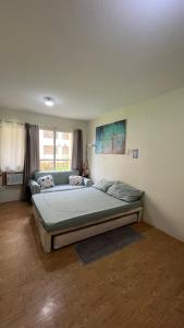 a bedroom with a bed and a couch in it at San Remo Oasis Cebu- Vic Place in Cebu City