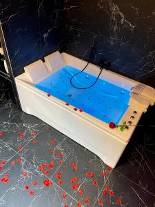 une baignoire remplie d'eau et de fleurs rouges sur un comptoir dans l'établissement R.Suite, à Saint-Étienne