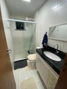 a bathroom with a shower and a sink and a toilet at Beach thoow férias in Arraial do Cabo +9 photos