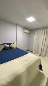 a bedroom with a large bed with a blue blanket at Beach thoow férias in Arraial do Cabo +9 photos