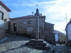 a stone building with a cross on top of it at Casinha Garcia in Penha Garcia