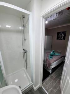 a bathroom with a shower and a toilet and a bed at Easy Living Nottingham - Burns Street in Nottingham