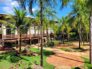 a resort with palm trees in front of a building at Hotel Pousada Águas de Bonito in Bonito