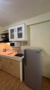 a kitchen with a sink and a refrigerator at San Remo Oasis Cebu- Vic Place in Cebu City