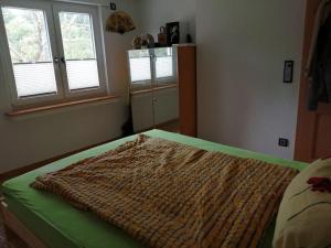 a bedroom with a bed with a large blanket on it at Ferienwohnung Apartment Doppelzimmer in der Villa Naturpark Rheinblick, ruhig, Aussicht, Pool in Koblenz