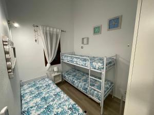 Habitación con 2 literas y sábanas azules y blancas. en Splendida Villetta San Teodoro en San Teodoro