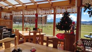 a dining room with a christmas tree and a table at Hosteria Lago del Toro in Torres del Paine
