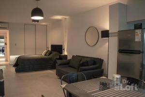 una sala de estar con un sofá y una cama en Dr. Loft - Apart céntrico en la ciudad de Rosario, en Rosario