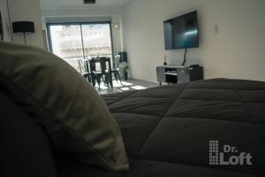 Un dormitorio con una cama, un televisor y sillas. en Dr. Loft - Apart céntrico en la ciudad de Rosario, en Rosario 17 fotos más