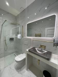 Baño blanco con lavabo y aseo en Laurieston Inn, 