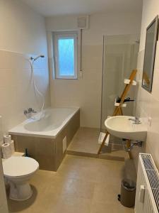 a bathroom with a tub and a toilet and a sink at Eine modern renovierte Wohnung mit Balkonterrasse. in Lübbecke