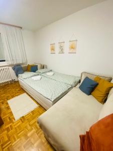 um quarto com 2 camas e um sofá em Studio Apartment Dobrinja em Sarajevo