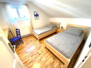 ein kleines Schlafzimmer mit 2 Betten und einem Stuhl in der Unterkunft Wohnzeit-Köln in Köln