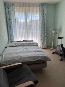 a bedroom with a bed and a window and a chair at Beautiful house with free parking on premise in Utzenstorf
