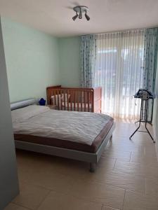 a bedroom with a bed and a large window at Beautiful house with free parking on premise in Utzenstorf