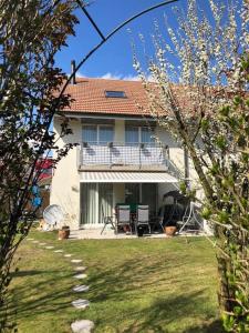 a white house with a balcony and a yard at Beautiful house with free parking on premise in Utzenstorf