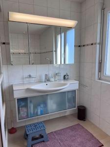 ein Bad mit einem Waschbecken und einem Spiegel in der Unterkunft Beautiful house with free parking on premise in Utzenstorf