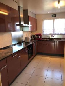 a large kitchen with brown cabinets and a window at Beautiful house with free parking on premise in Utzenstorf