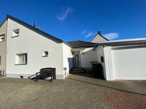 un banco sentado frente a una casa blanca en Wohnzeit-Köln en Colonia