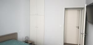 1 dormitorio con paredes blancas, 1 cama y armario en Appartement T2 45 m² en centre-ville, en Ax-les-Thermes