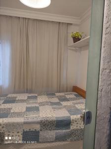 ein Schlafzimmer mit einem Bett mit einer blau-weißen Decke in der Unterkunft Apartamento em Balneário Camboriú centro,quadra mar in Balneário Camboriú