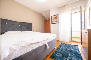 ein Schlafzimmer mit einem Bett und einem großen Fenster in der Unterkunft Norandvik Apartment in Podgorica