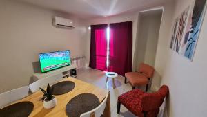 uma pequena sala de estar com uma mesa e uma televisão em Confort Río Cuarto I em Río Cuarto