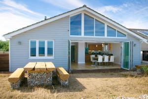 a house with a picnic table in front of it at Wow I'm living on the beach. Luxury 4 bed sleeps 8 in Pagham