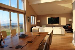 a living room with a large wooden table and a bed at Wow I'm living on the beach. Luxury 4 bed sleeps 8 in Pagham