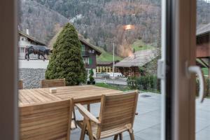 a table and chairs on a patio with a view of a house at Melchtal Resort Apart Hotel in Melchtal