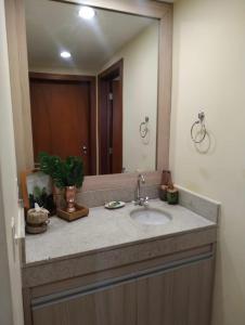 La salle de bains est pourvue d'un lavabo et d'un miroir. dans l'établissement Aldeia das Águas Park Resort - Flat B309 Quartier, à Barra do Piraí