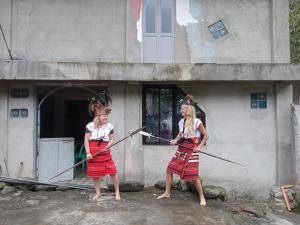 two girls are standing outside of a building at Cambulo Am-way Tavern in Banaue