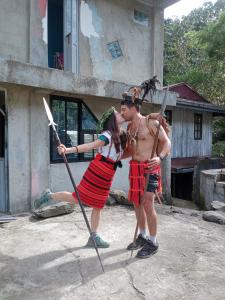 a man and a woman dressed in indian costumes with skis at Cambulo Am-way Tavern in Banaue