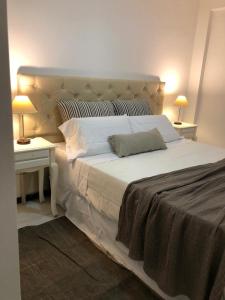 1 dormitorio con 1 cama blanca grande y 2 mesitas de noche en CALMA en La Rioja