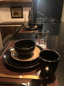 una mesa con platos, tazones y vasos. en Black Loft. Moderno y nuevo, súper ubicado., en Ciudad de México