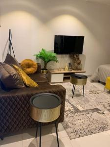 ein Wohnzimmer mit einem Sofa und einem TV in der Unterkunft The Lennox suite Airport residential Area in Accra