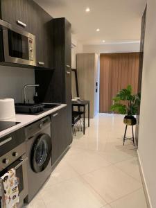 eine Küche mit einer Waschmaschine und einem Waschbecken in der Unterkunft The Lennox suite Airport residential Area in Accra