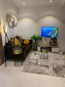 ein Wohnzimmer mit einem Sofa und einem Flachbild-TV in der Unterkunft The Lennox suite Airport residential Area in Accra