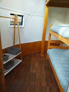 a attic room with two bunk beds and a window at Lemudomos in Pichilemu