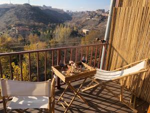 uma mesa e 2 cadeiras numa varanda com vista em Karen's Dom & Terrace em Yerevan