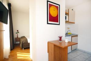 a kitchen and a living room with a table at Séjours & Affaires Nantes La Beaujoire in Nantes