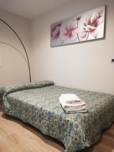a bed in a room with a picture on the wall at Apartamento Servet, parking gratuito, a 5 minutos de Sevilla in Bormujos